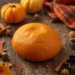 Child playing with homemade pumpkin spice playdough and cookie cutters