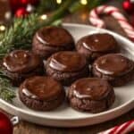 A batch of Andes mint cookies cooling on a wire rack with holiday lights in the background