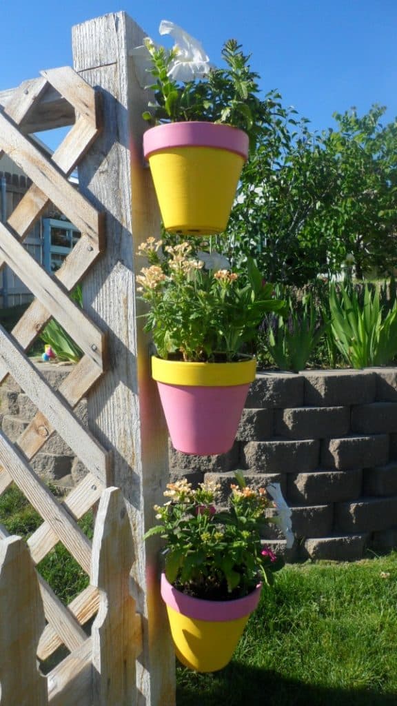 Easy DIY idea for hanging a painted flower pot on a fence.