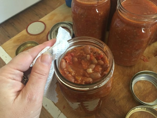 Filling jars for pressure canning home canned chili.