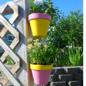 Creative ideas for decorating your backyard fence with DIY flower and herb planters.