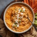 Holiday table spread featuring buffalo chicken dip and crackers