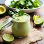 Zesty avocado lime dressing drizzled over a vibrant green salad with cherry tomatoes.