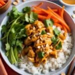 Enjoy a gluten-free Thai Peanut Chicken Bowl loaded with fresh vegetables, jasmine rice, and a savory peanut sauce. This flavorful bowl is perfect for a nutritious and filling lunch or dinner.