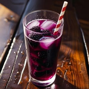 Homemade blackberry iced tea served in a mason jar with ice and lemon slices