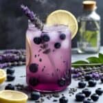 Glass of blueberry lavender lemonade with fresh blueberries and lavender sprigs