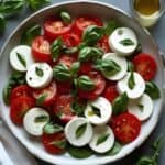 Bright summer Caprese salad with ripe tomatoes, fresh mozzarella, basil, and olive oil