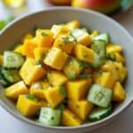 Vibrant cucumber mango salad garnished with mint leaves