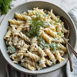 Bowl of creamy dill pasta salad with fresh herbs