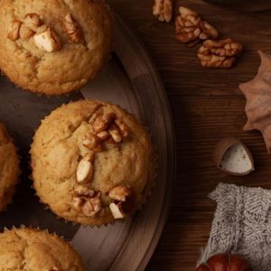 Muffins topped with cream cheese frosting, walnuts, and cinnamon sugar