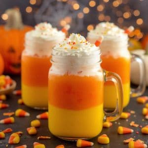 Halloween food drink inspired by candy corn with whipped cream topping in clear glasses