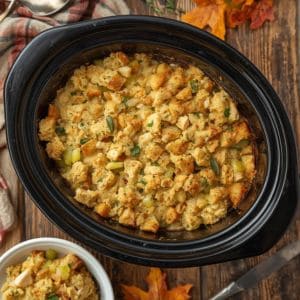 Slow cooker chicken dressing in a crockpot with herbs and golden stuffing