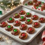 Christmas Rolo pretzels cooling on parchment paper.