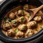 A bowl of Swedish meatballs garnished with fresh parsley.